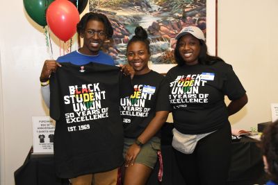Black Student Union 50th anniversary celebration with 3 students wearing or holding commemorative T-shirts