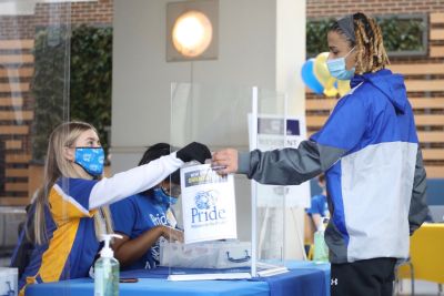 New student checking into Widener and receiving an info packet from another student.