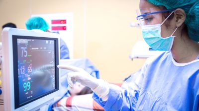 critical aute care nurse reads ICU monitor