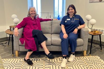 President Stacey Robertson and Lizzy Martin sit side-by-side on a couch.