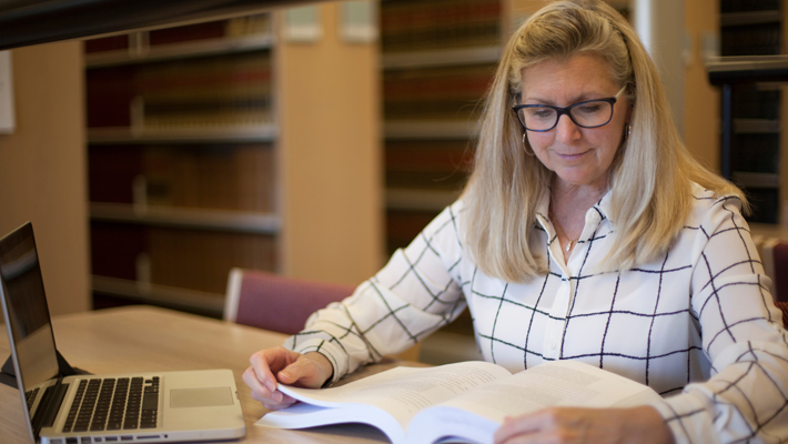 Graduate Student Studying in Library 710x400 Graduate Student Studying in Library