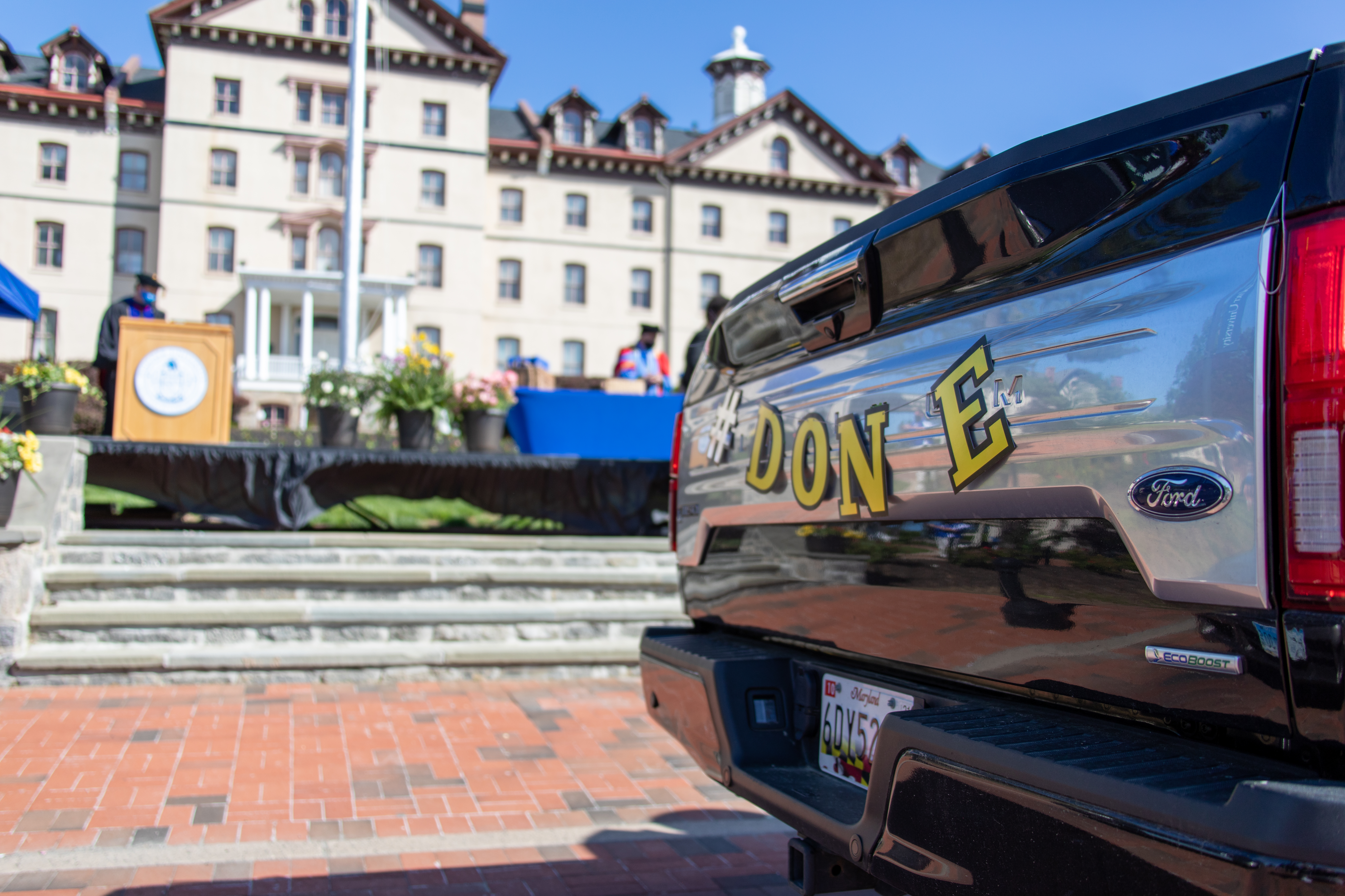 Truck decorated with the word "done" parks in front of Old Main building