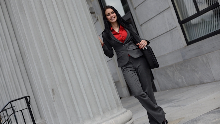 Criminal justice career woman standing outside of a courthouse.