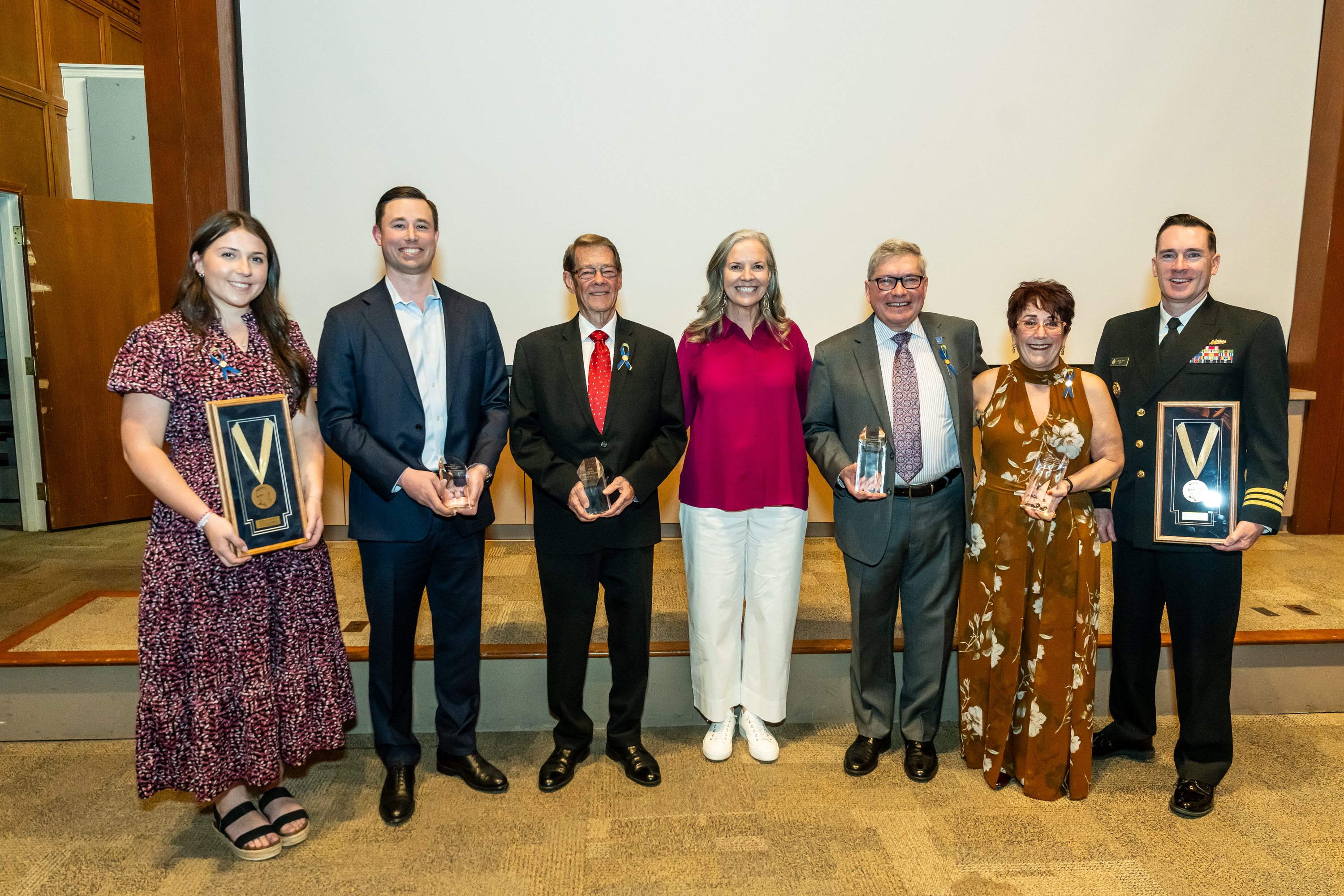 Six alumni award winners pose with President Stacey Robertson, holding their awards