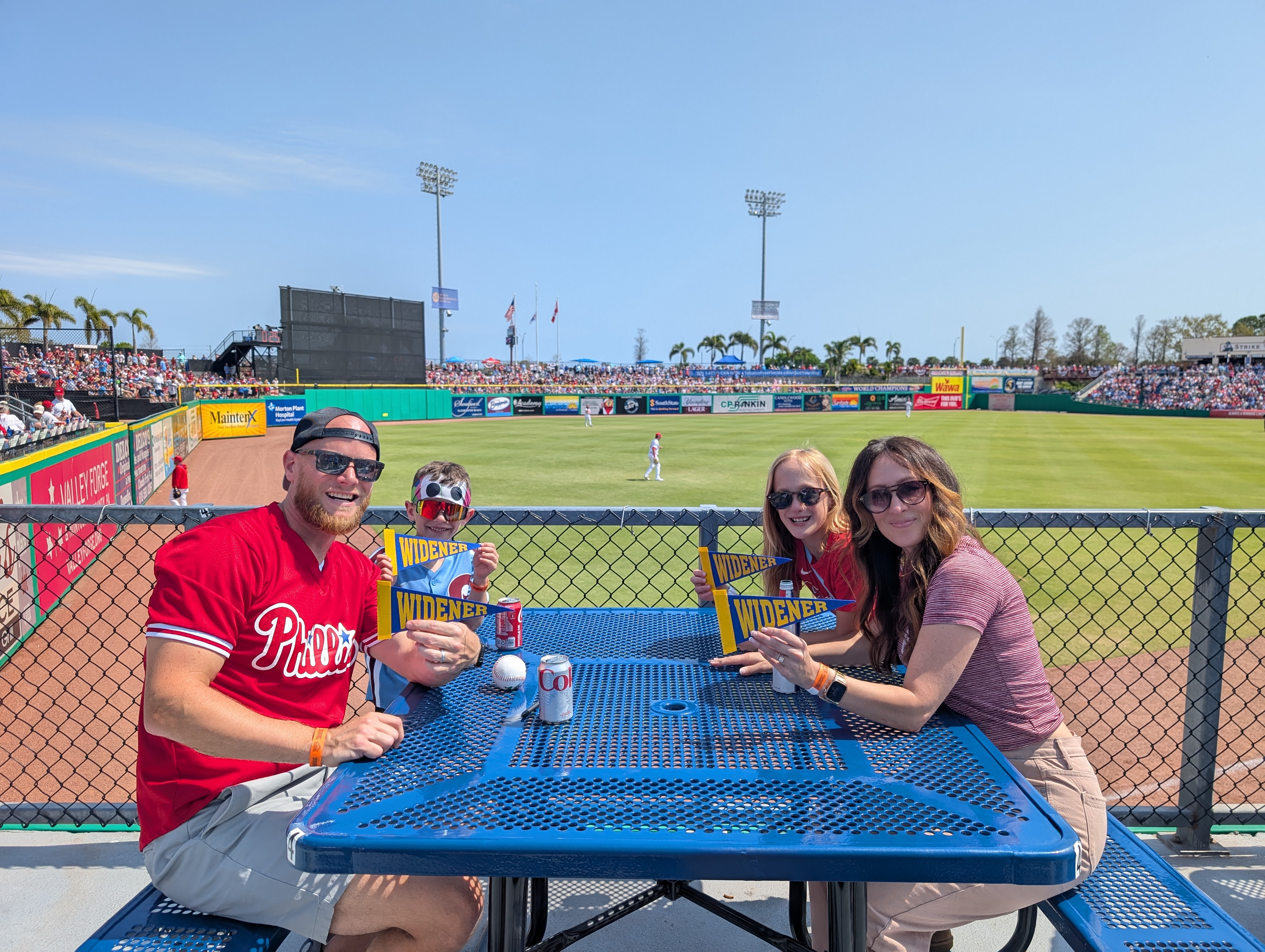 Alumni and their families enjoying the sun at the game