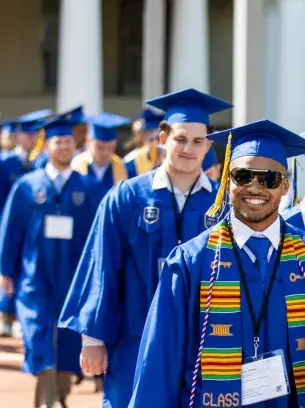 Widener graduates walking in their robes at a graduation ceremony