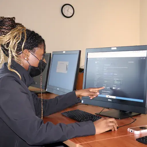 Desiree Junfijiah points to a computer screen she's working on