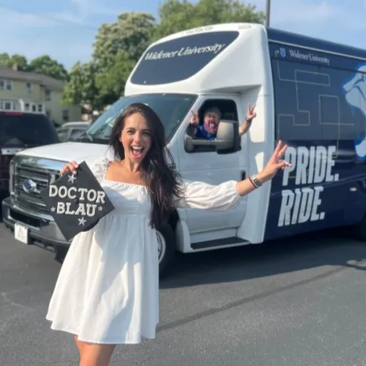 Human sexuality studies graduate Carli Blau poses with her graduation cap that says "Doctor Blau" along with the Pride Ride driver