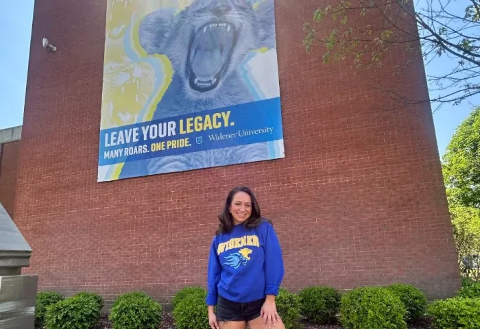 Belle Nicholas Kapelski banner 960 x 640 Belle Nicholas poses in front a mural on Widener's campus that reads "Leave Your Legacy."