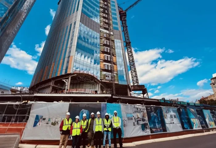 Construction management header 960 x 640 Students stand at a large skyscraper construction site.