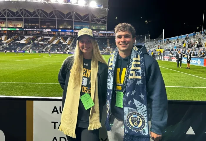Mackenzie Cahall and Tyler Grose pose for a photo on the sidelines of Subaru Park.