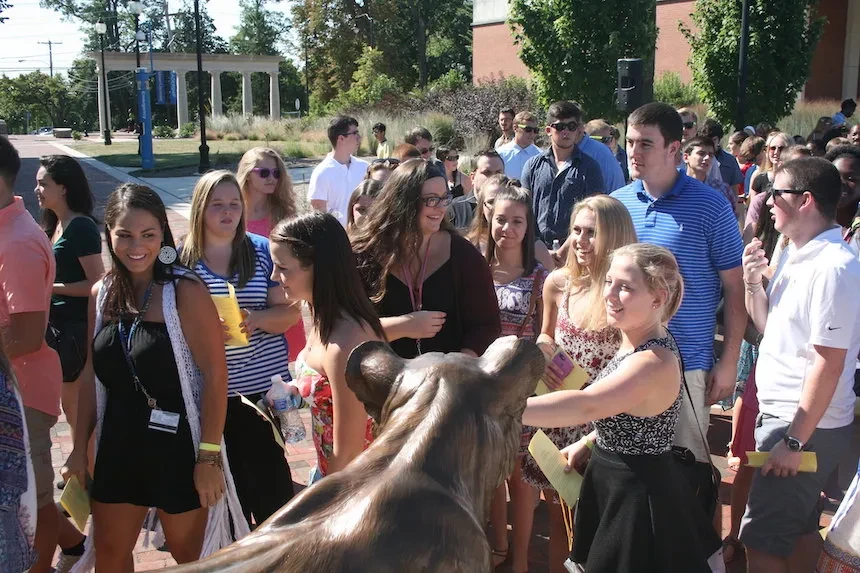 students touch the lion's nose for good luck