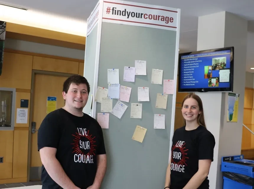 Courage Day student volunteers at bulletin board