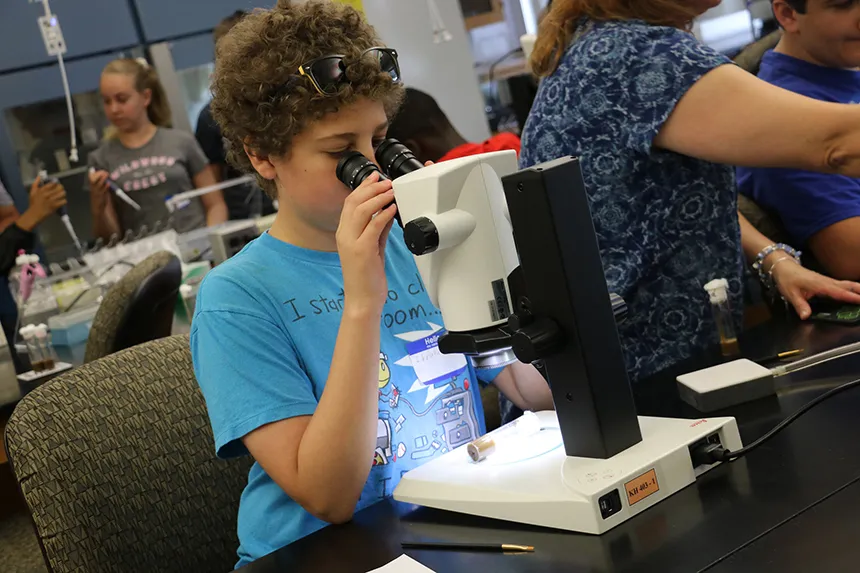summer camp student with microscope