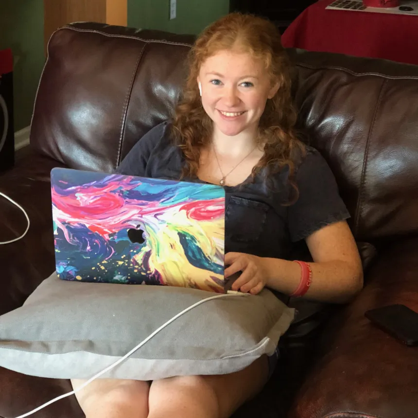 Student sitting on sofa with laptop