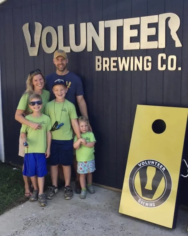 Schatz family standing in front of Volunteer Brewing Co. sign