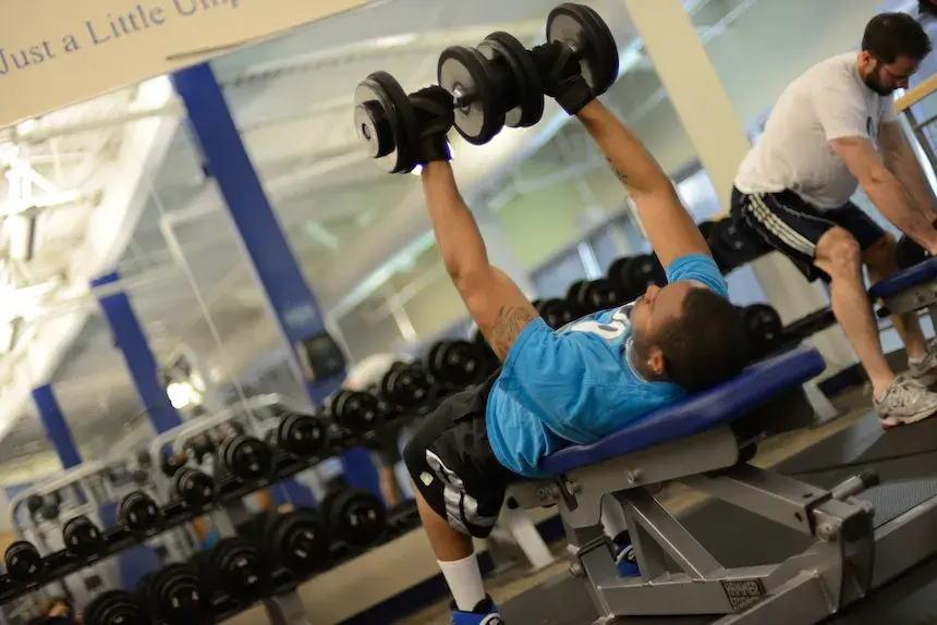 widener student works out using weight lifting bench