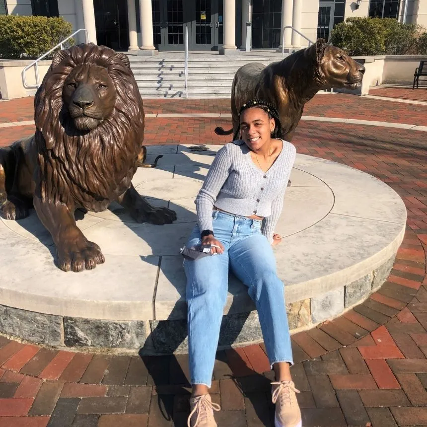 Donya Moore sits in front of Pride Lion statues