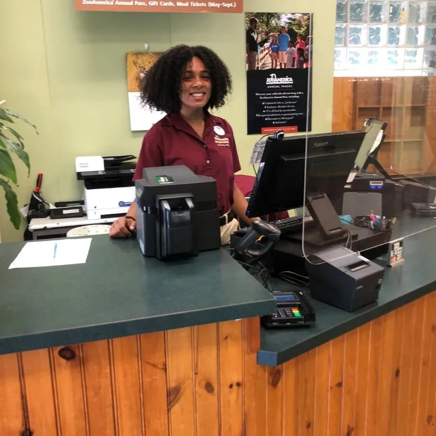 Donya Moore stands at a desk and computer in Hershey Park