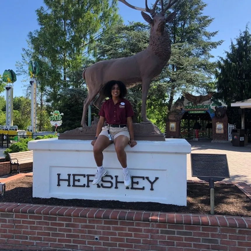 Donya Moore sits in front of a statue at Hershey Park