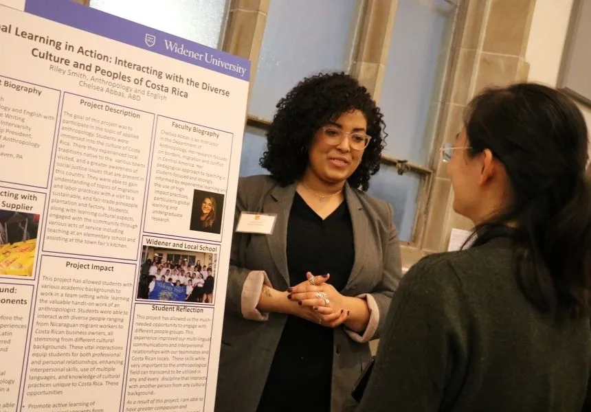 A female student presents her research at the HIP Fair.