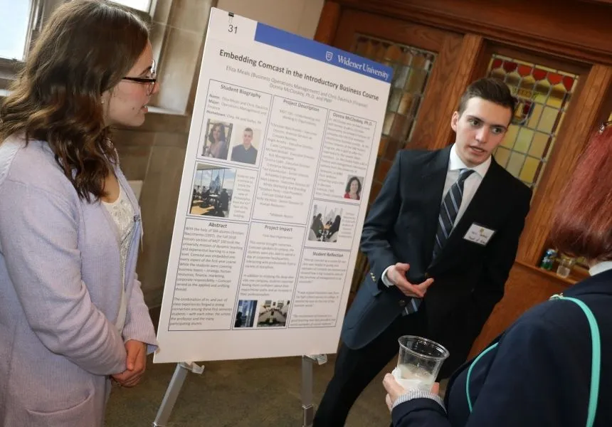 A female and male student present their research at the HIP Fair.