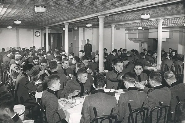Black and white photo of cadets eating in the Old Main mess hall