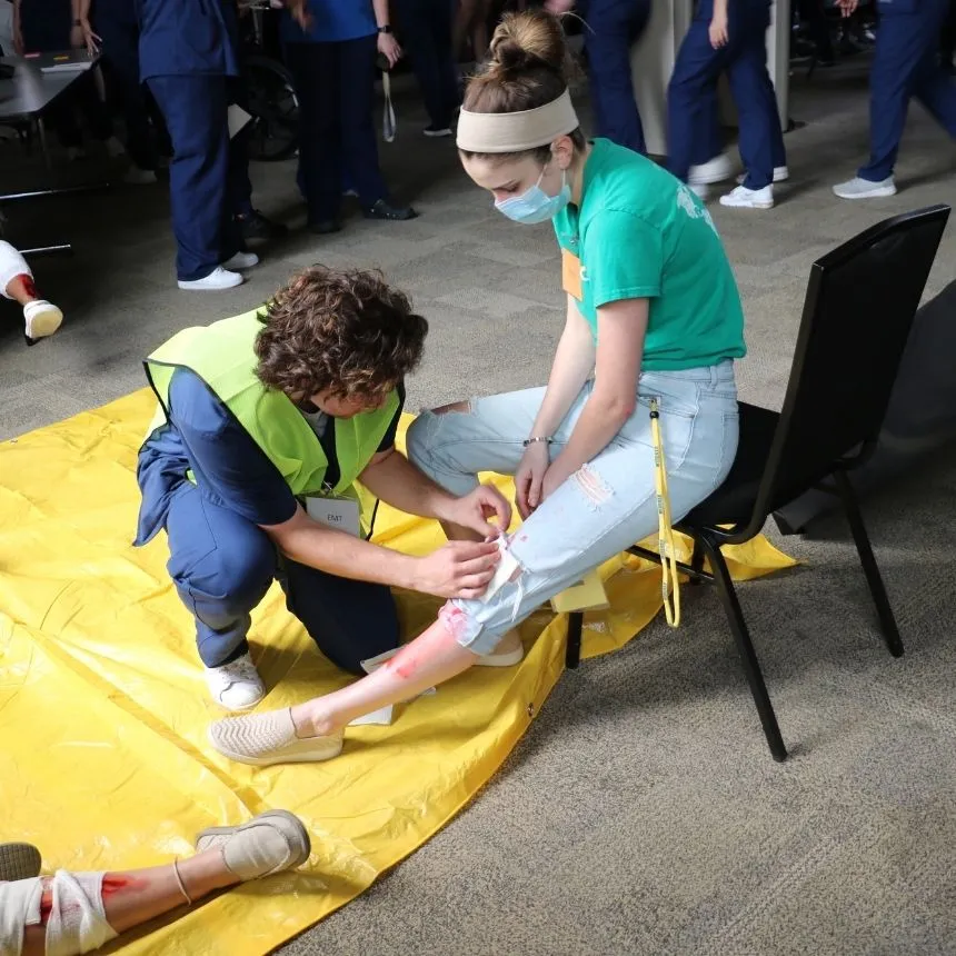 A male nursing students wraps a leg wound