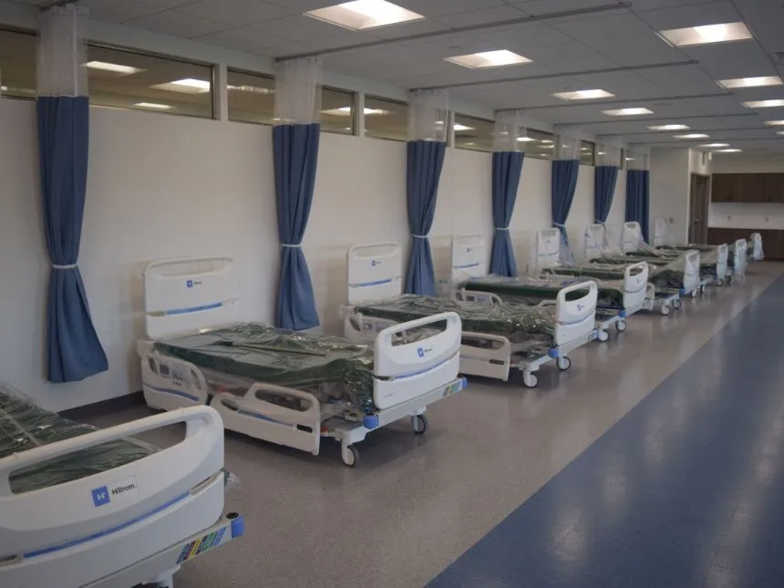 A lab space is lined with hospital beds.