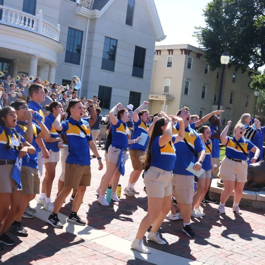 CREW leaders sign Widener's school song at the Pride statues.