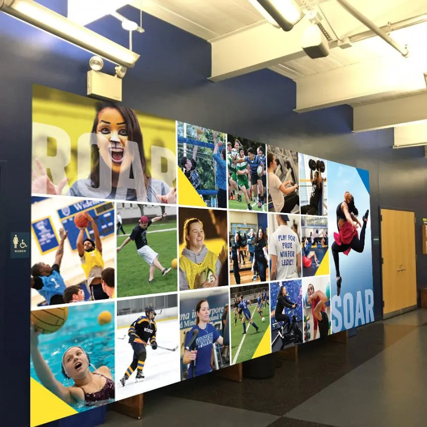 A colorful mural filled with pictures of students across campus covers the back wall of the Pride Rec Center