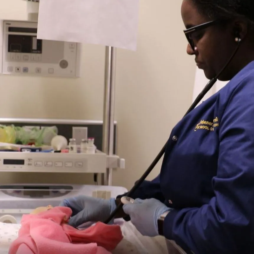 A female student evaluates a newborn mannequinn