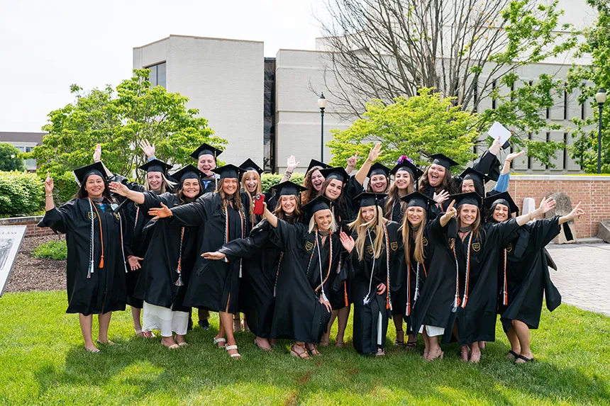 Group of Speech Language Pathology grads in black caps and robes 