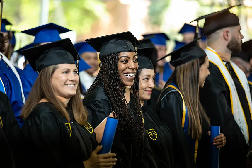 A row of graduate students in black caps and gowns