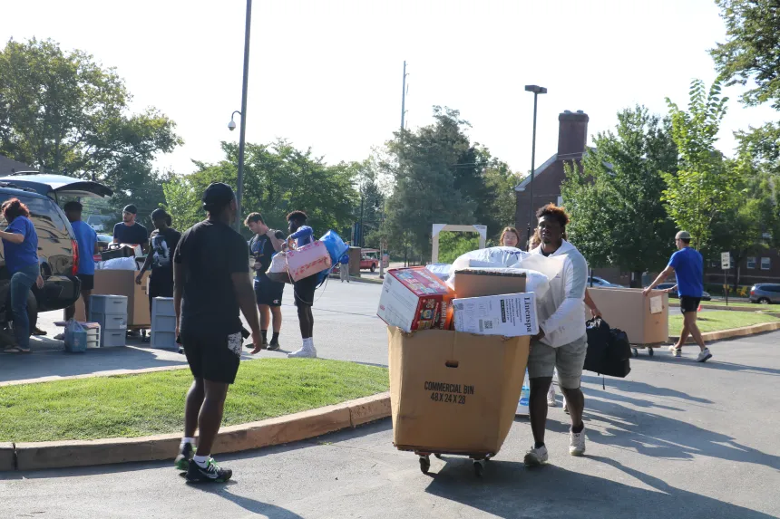 Students wheel a cart full of items 