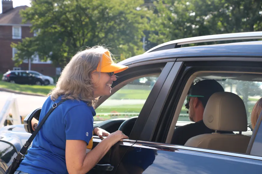 President Robertson greets a student through a car window