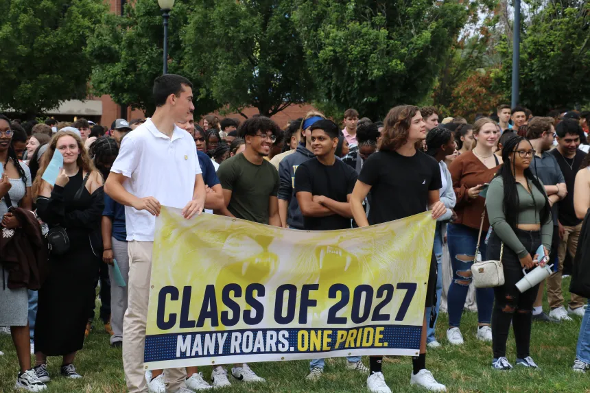 Students hold a yellow banner saying 'Class of 2027'