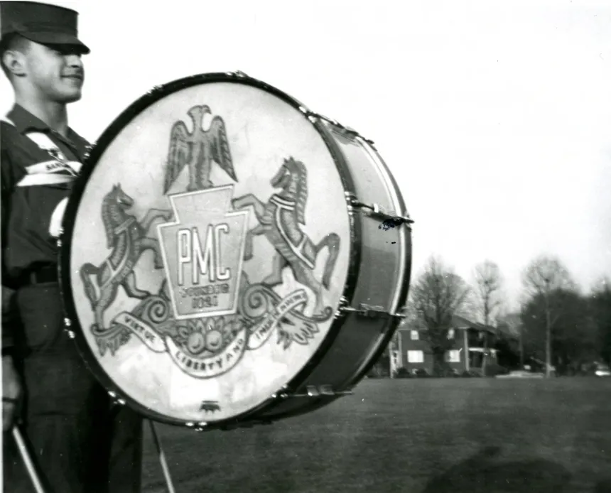 Black and white photo of PMC Band member holding a drum