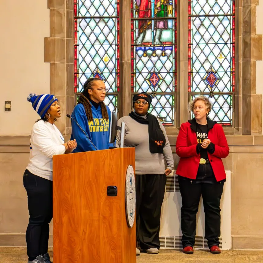 Marina Barnett and others speak at a podium during the opening ceremony.
