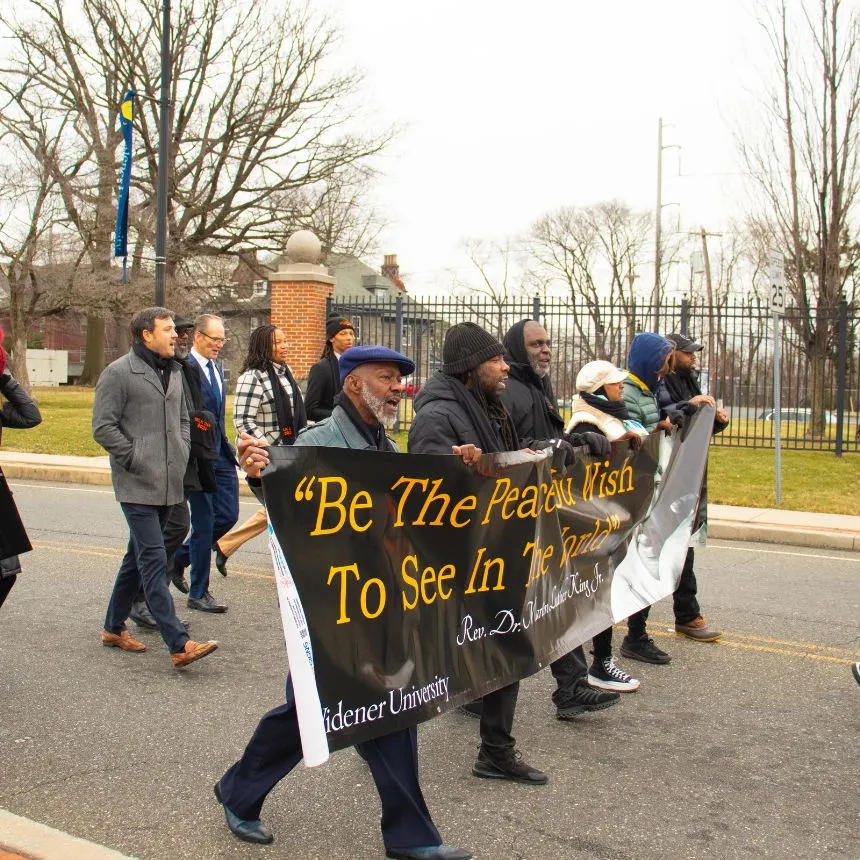Individuals lead a peace march from Widener's campus to Chester City Hall.