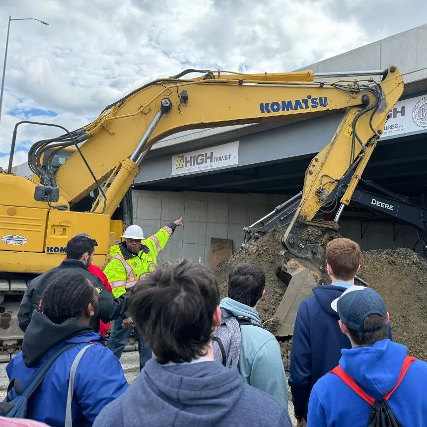 Engineering students walk with construction management professionals on an active work site.