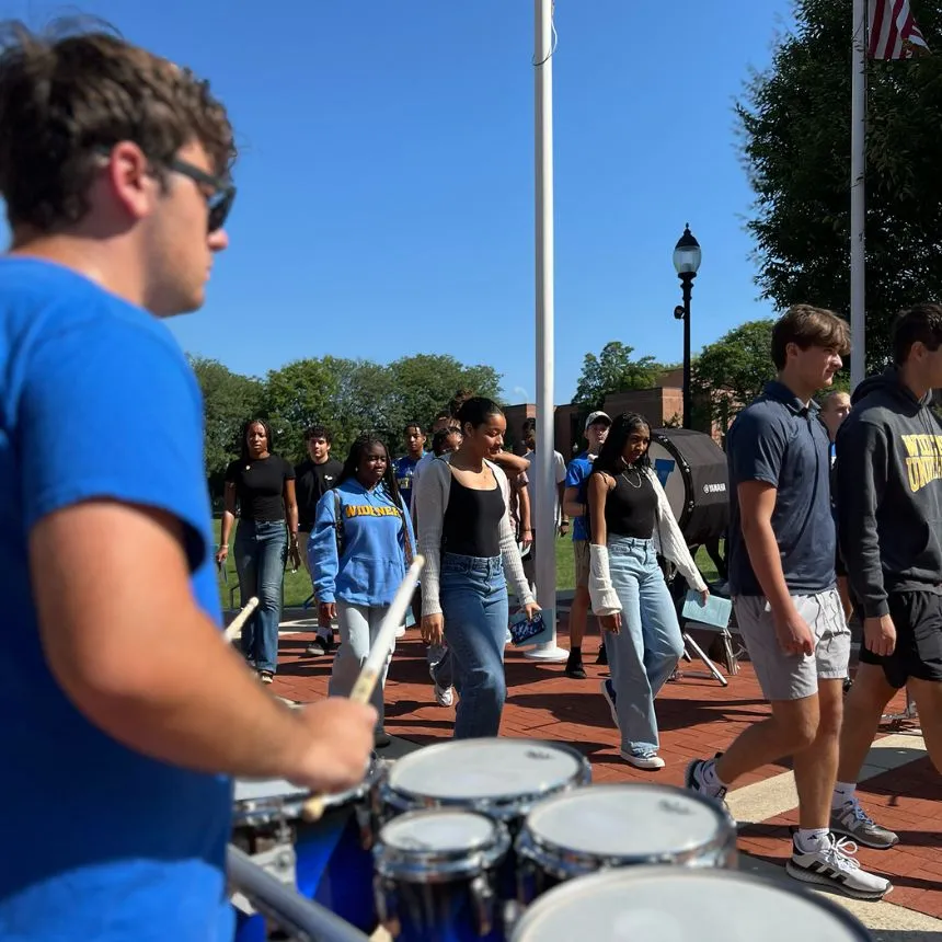 Students walk past the drum line at convocation.