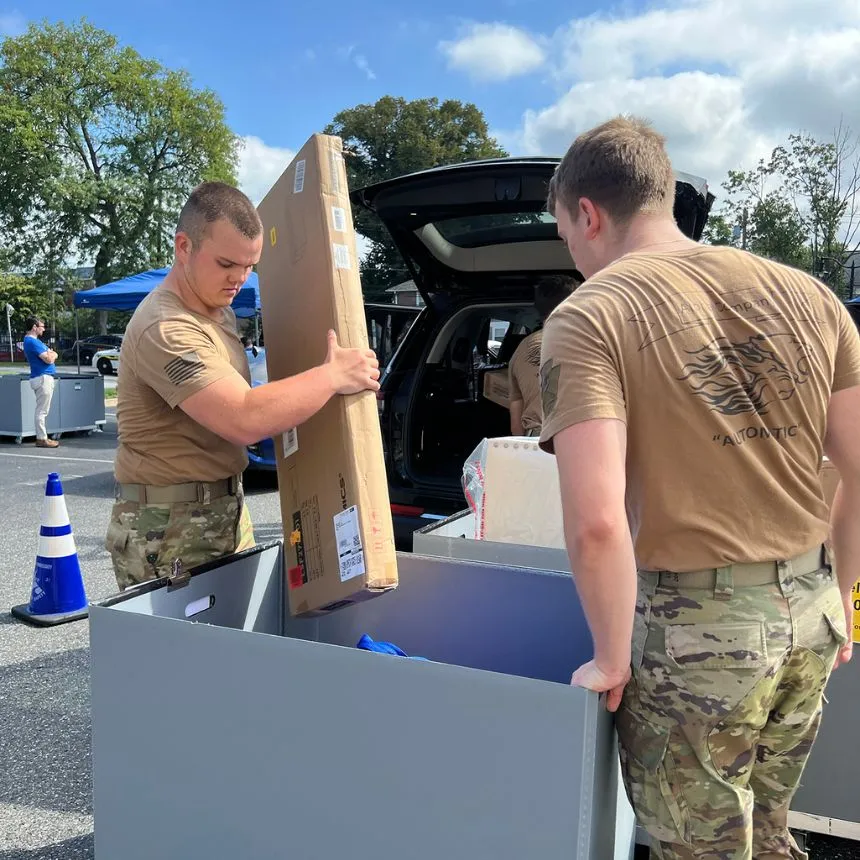 ROTC cadets help unload at car at move-in day.