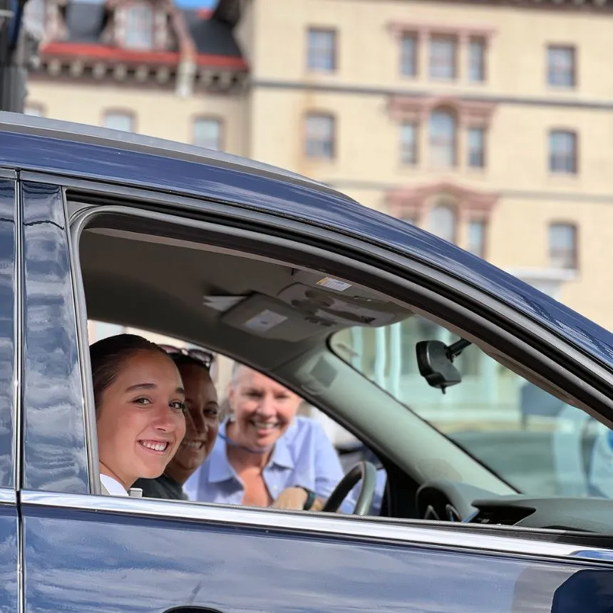 Stacey Robertson talks to a family sitting in their car arriving at move-in day.