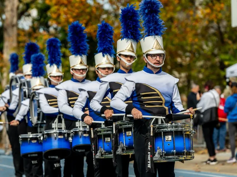 The Marching Band drumline processes in uniform.