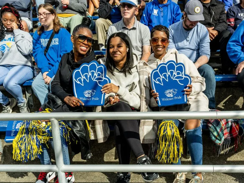 Fans cheer on the football team from the stands.