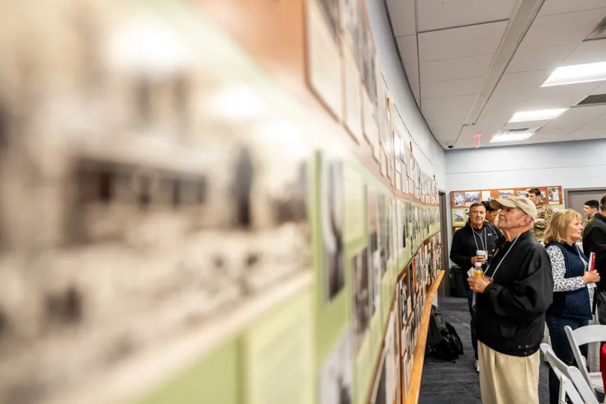 A PMC alumnus reads Widener's historical timeline on the wall of Alumni Auditorium.