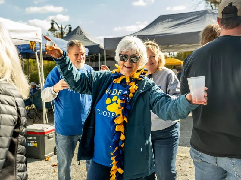 A Widener alumna celebrates at the football tailgate.