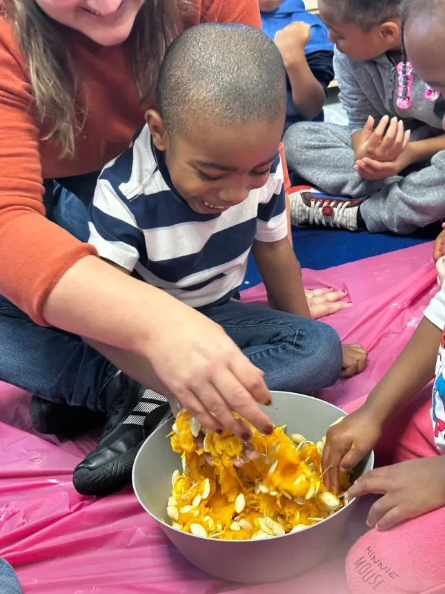 CDC student playing with pumpkin