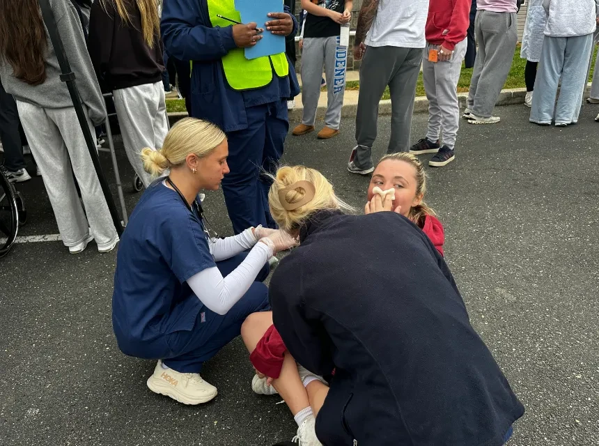 Nursing students treat a "patient" in a simulated disaster event on campus.